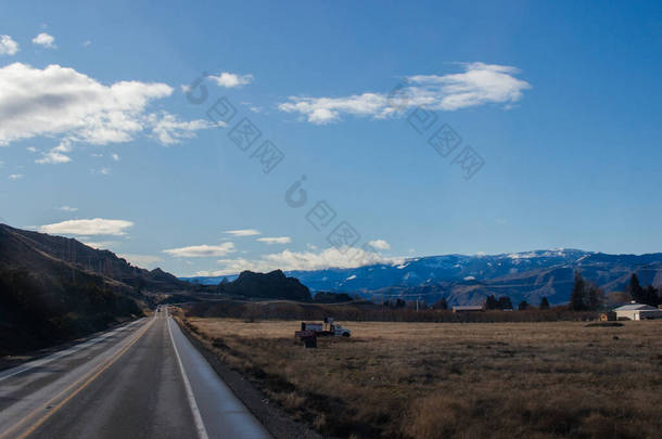 美国华盛顿州，秋天的风景，山中有一条公路，背景是蓝天蓝山