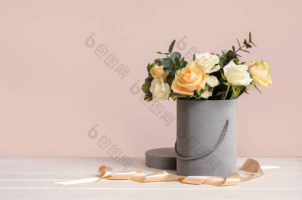礼品盒,桌子上放着美丽的花朵,衬托着彩色背景
