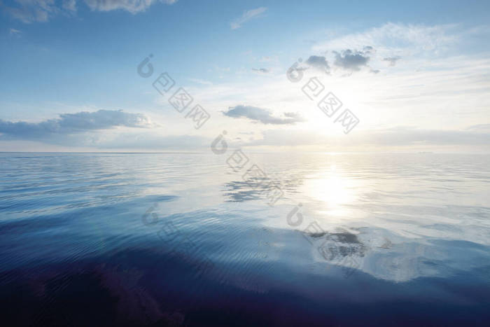 日落时，波罗的海上空蓝蓝的天空闪烁着卷云和积雨云。Idyllic海景。旅行，航行，游轮，娱乐，度假。水中的对称反射，天然镜