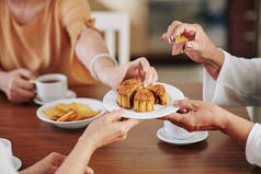 在家中庆祝中秋节时，年长妇女的手在吃着美味的传统月饼