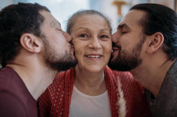 儿子们祝贺妈妈<strong>放假</strong>.哥哥们送给一位年迈美丽的母亲一束鲜花。男人在假日拜访他们心爱的母亲