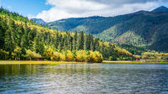 云南香格里拉国家公园的树都湖风景与秋天的五彩斑斓的森林与远山