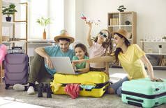 快乐的家庭和孩子们带着旅行箱在网上订票