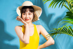 美丽的亚洲女人穿着蓝色背景的黄色连衣裙，还有夏天的概念