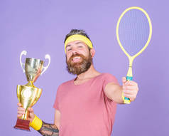 赢了我参加的每一场网球比赛。网球选手赢得冠军.运动员拿着网球拍和金杯.赢了网球比赛留着胡子的嬉皮士穿着运动服.成功与成就
