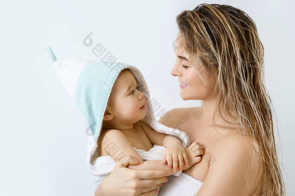 婴儿卫生和护理。<strong>年轻</strong>快乐的<strong>妈妈</strong>和她可爱的小儿子洗完澡后.