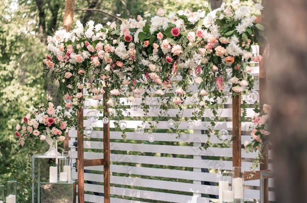 结婚仪式。非常漂亮和时尚的婚礼拱门，装饰着各种鲜花，矗立在花园里.