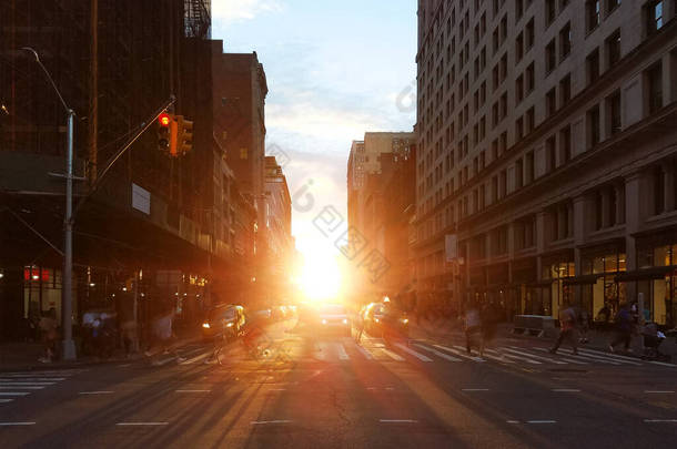 纽约市曼哈顿中城的23街，<strong>人们</strong>走过繁忙的十字路口，背景上闪烁着夕阳的光芒