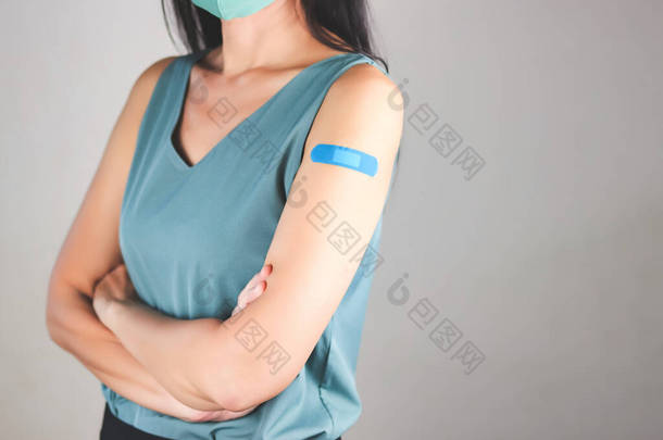 注射柯罗纳威疫苗后，身穿绿色<strong>无袖</strong>T恤、头戴布制口罩、腋下打着石膏绷带的亚洲妇女的剪影.