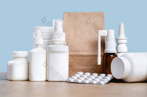 在线药房。处方药和非处方药，随时可提供给客户。填充和喷涂白色的模拟容器和纸袋在桌子上。药店购物