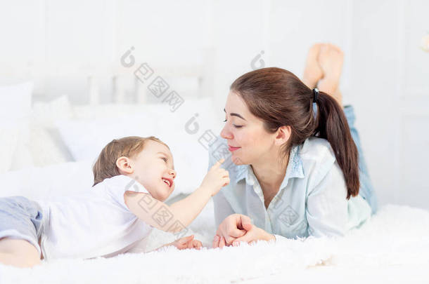 <strong>母亲</strong>和婴儿在家里床上玩耍，家庭和<strong>亲子</strong>关系的概念