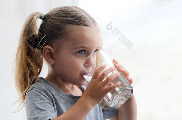 小女孩喝纯净水窗台背景图