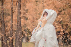 秋天森林里穿着白衣的年轻漂亮女子