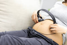 带耳机孕妇胃部的剪贴照片.