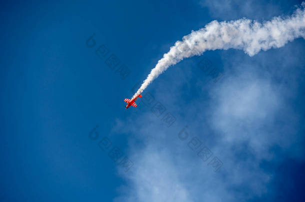 2021年7月24日，在朱可夫斯基的Max-21航空航天沙龙，红色的飞机在蓝色的天空中艰难地转弯，喷出了白烟