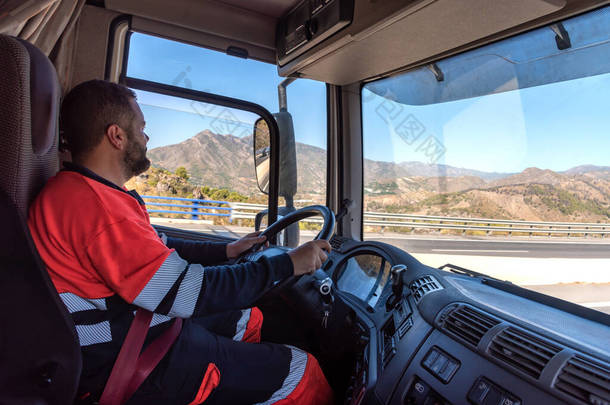 <strong>卡车</strong>司机在驾驶位置，双手握住方向盘，驾驶.