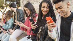 一群朋友在户外用他们的智能手机玩游戏-快乐的年轻人在户外用手机。技术概念.