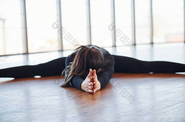 <strong>身穿</strong>黑色<strong>运动服</strong>的胖女人伸懒腰躺在地板上.