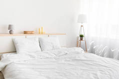 双人床，有舒适的床上用品，植物灯，家具