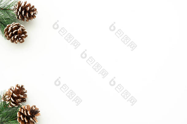 白色桌子，圣诞装饰包括松枝和松果。圣诞快乐,新年快乐.顶部视图，带有复制空间，平面布局.