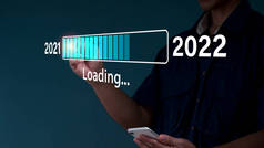 一名商人在新年前夕触摸了一个虚拟的下载栏，上面有一个加载的进度条，将2021年改为2022年.