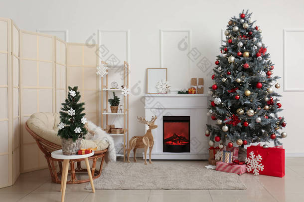 室内有<strong>壁炉</strong>、圣诞树和折叠式屏风的照明<strong>客厅</strong>