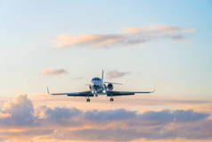 一架私人喷气式飞机，背景是美丽柔和的天空，夕阳西下，乌云密布，粉色和蓝色调