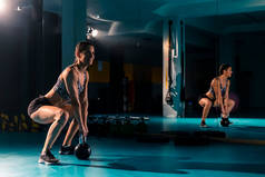 一个体格健康的年轻女子在健身房做举重运动.