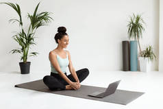 Online Training. Smiling Sporty Female Practicing Yoga In Front Of Laptop