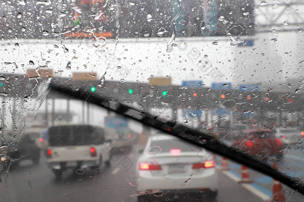 高速公路收费站雨天使用汽车挡风玻璃雨刷开车的前景.