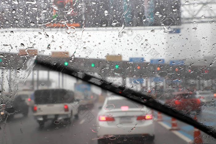 高速公路收费站雨天使用汽车挡风玻璃雨刷开车的前景.