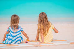 快乐的小女孩们在热带海滩玩得很开心
