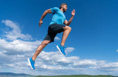 肌肉发达的男子在户外穿着运动服在天空背景下奔跑，挑战