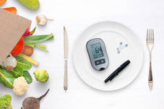 血糖计，带有带的盘子概念。袋子里有健康的食物和蔬菜.健康饮食和糖尿病控制的概念 