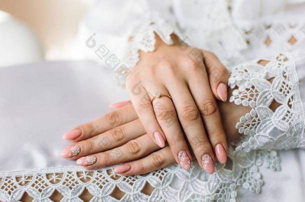 新娘手指上的订婚戒指。裙子上<strong>漂亮</strong>的<strong>花边</strong>.