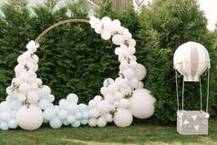 度假派对的装饰。很多气球都是蓝色和白色的。带着球的圆形照片区域，旁边是一个装有篮子的儿童球
