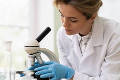 女科学家在实验室的研究工作中使用显微镜