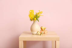 在房间里靠近彩墙的桌子上涂上美丽的油花枝条和装饰