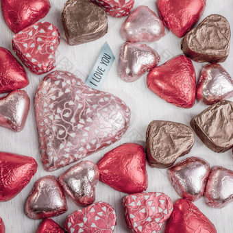 许多心形状的<strong>巧克力</strong>色彩斑斓的包装传播出在表格的最大哪一个有标签那说爱你