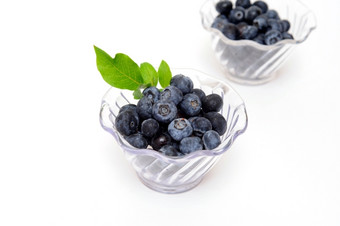 新鲜的选蓝莓清晰的塑料碗光彩色的背景蓝莓清晰的碗