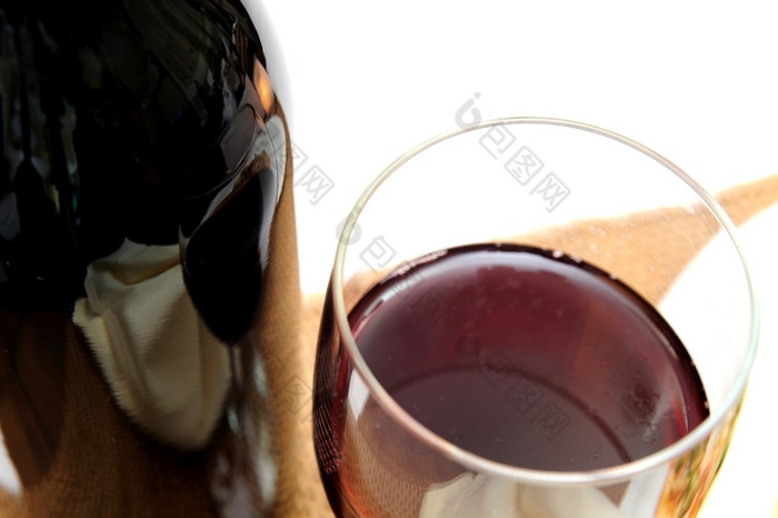 单玻璃红色的酒查看从以上与的周围风景反映了的瓶光彩色的背景玻璃红色的酒