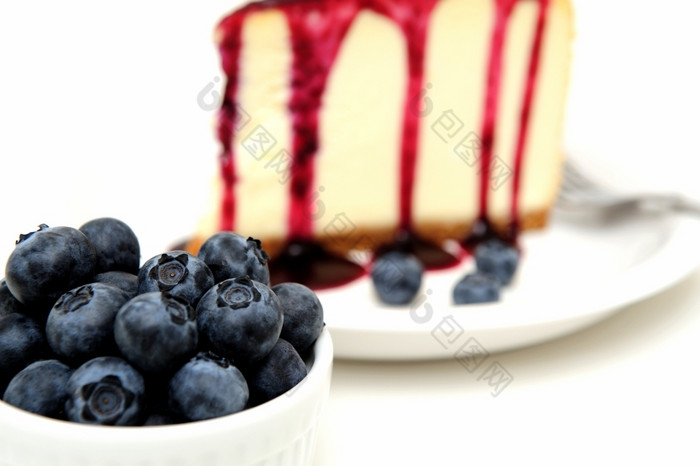 新鲜的蓝莓和芝士蛋糕平原芝士蛋糕与蓝莓酱汁倒在的前与新鲜的浆果的板下一个的蛋糕而且超过与薄荷叶