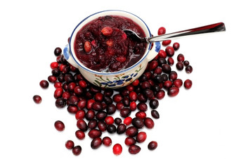 蔓越莓酱汁新鲜的小红莓白色背景与碗蔓越莓酱汁前的浆果