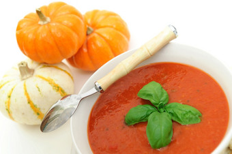 健康的番茄汤温暖的番茄汤超过与用钉子钉上新鲜的罗勒服务白色碗与微型南瓜的背景给的概念的秋天季节
