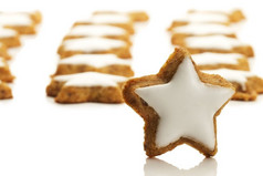 明星形状的肉桂饼干前面许多一个明星形状的肉桂饼干前面许多白色背景