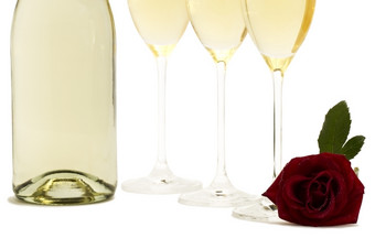 湿红色的玫瑰前面的底从三个香槟眼镜而且香槟瓶湿红色的玫瑰前面的底从三个香槟眼镜而且香槟瓶白色背景