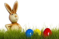 复活节兔子后面草与复活节鸡蛋复活节兔子后面草与复活节鸡蛋白色背景