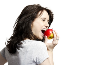 年轻的女人咬红色的苹果年轻的快乐女人吃红色的苹果