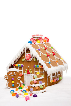 姜饼房子男人。而且圣诞节树覆盖与雪而且色彩斑斓的糖果冬天景观孤立的