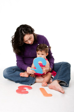 妈妈。保姆老师教学婴儿学习如何数一个两个三个与数字好玩的道路而坐着地板上